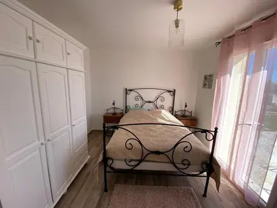 a bedroom with a bed and a large window at Villa Flora in La Gaude