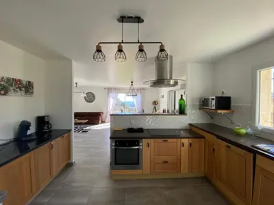 a kitchen with wooden cabinets and black counter tops at Villa Flora in La Gaude