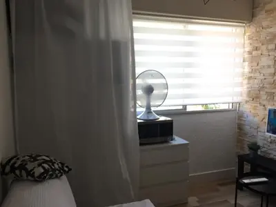 a bedroom with a window with a fan on a dresser at Studio à 2 pas de la promenade des anglais in Nice