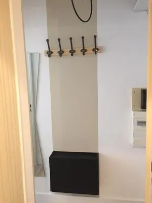 a room with a white wall with a black table at Studio à 2 pas de la promenade des anglais in Nice