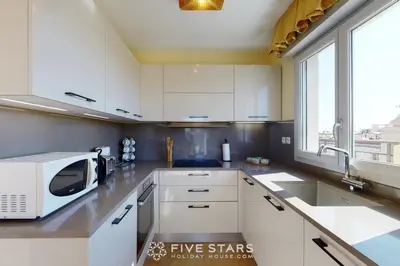 a kitchen with white cabinets and a microwave at LUXURY BEACH five STARS HOLIDAY HOUSE in Nice