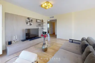 a living room with a couch and a tv at LUXURY BEACH five STARS HOLIDAY HOUSE in Nice