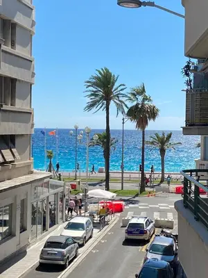 a street with cars parked next to the beach at City center cute flat with sea view one bedroom in Nice