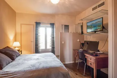a bedroom with a bed and a desk with a computer at 