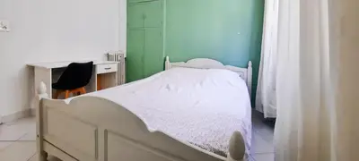 a white bed in a room with a green wall at Appartement 3 pièces Nice Hypercentre in Nice