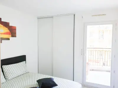 a white bedroom with a bed and a window at Résidence Les domes, Piscine in Nice
