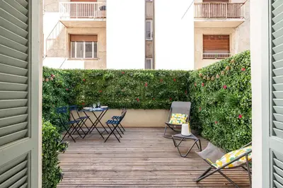 a patio with chairs and a hedge with flowers at 60 HEROLD - Magnifique Studio - Terrasse - Climatise in Nice