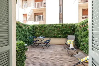 a patio with chairs and a hedge with red flowers at 60 HEROLD - Magnifique Studio - Terrasse - Climatise in Nice