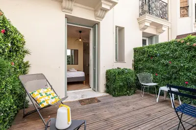a patio with a grill and chairs and a bedroom at 60 HEROLD - Magnifique Studio - Terrasse - Climatise in Nice