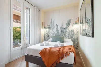 a bedroom with a king sized bed with a tropical wallpaper at 60 HEROLD - Magnifique Studio - Terrasse - Climatise in Nice