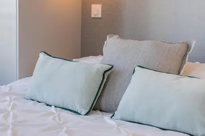 a group of pillows sitting on top of a bed at 2 BAVASTRO - Beau 2 pieces lumineux et cosy - Climatise in Nice