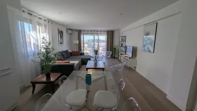 a living room with a glass table and chairs at Les Volets Bleus in Nice