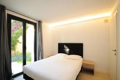 a bedroom with a white bed and a large window at Les Volets Bleus in Nice