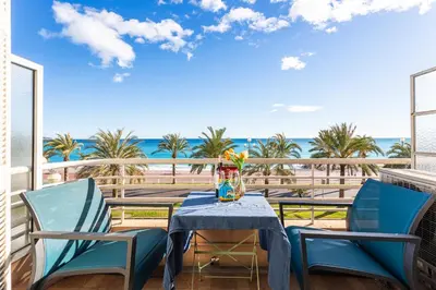 a table and chairs on a balcony with a view of the beach at BAMBOO PLAGE AP4220 by Riviera Holiday Homes in Nice
