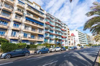 a street with cars parked in front of a building at BAMBOO PLAGE AP4220 by Riviera Holiday Homes in Nice