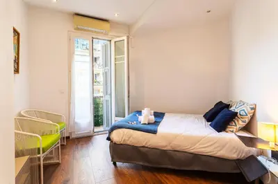 a bedroom with a bed and a large window at BAMBOO PLAGE AP4220 by Riviera Holiday Homes in Nice