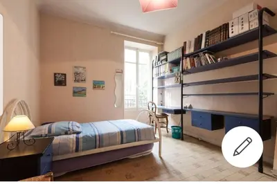 a bedroom with a bed and a shelf with books at Chambre chez particulier centre ville - Nice in Nice