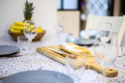 a table with wine glasses and a cutting board with bread at Magnifique appartement au centre-ville de Nice in Nice