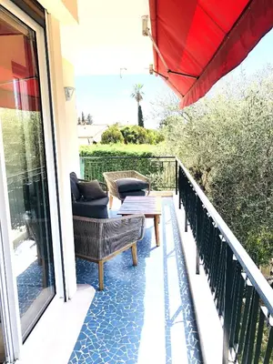 a balcony with chairs and a table and an umbrella at Beautiful T3 terrasse Nice in Nice