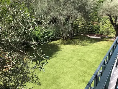 a yard with a fence and green grass at Beautiful T3 terrasse Nice in Nice