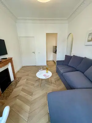 a living room with a blue couch and a table at ChezDudi in Nice