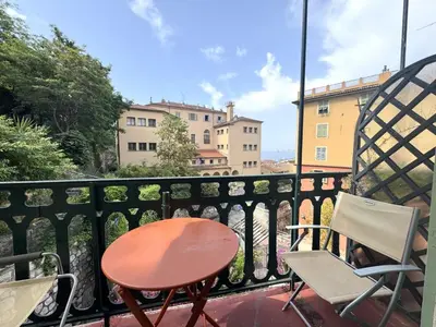 a balcony with a table and chairs on a balcony at ApartHotel Riviera - BALCON HONORE 1 - Old Town - 5 mn Promenade des Anglais et Plage - Charme Absolu - Appartement 2 pièces avec Balcon AC - Vue mer et Ville in Nice
