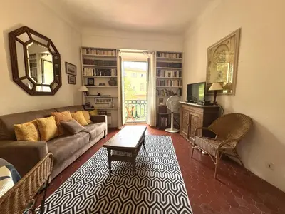a living room with a couch and a mirror at ApartHotel Riviera - BALCON HONORE 1 - Old Town - 5 mn Promenade des Anglais et Plage - Charme Absolu - Appartement 2 pièces avec Balcon AC - Vue mer et Ville in Nice