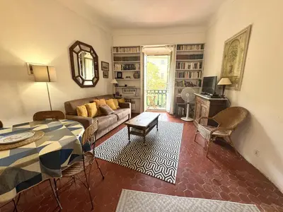 a living room with a table and a couch at ApartHotel Riviera - BALCON HONORE 1 - Old Town - 5 mn Promenade des Anglais et Plage - Charme Absolu - Appartement 2 pièces avec Balcon AC - Vue mer et Ville in Nice