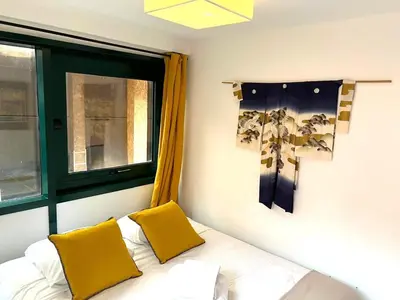 a white bed with two yellow pillows on it at Dana centre mer 16 in Nice