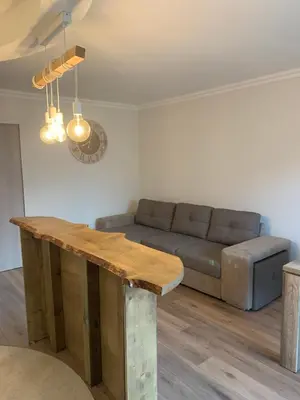 a living room with a couch and a wooden table at Superbe 2 pièces à 50 m de la Promenade des Anglais in Nice