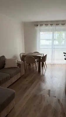 a living room with a table and a couch at Superbe 2 pièces à 50 m de la Promenade des Anglais in Nice