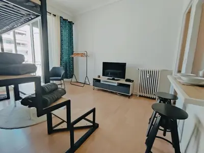 a living room with a tv and some chairs at Joli Studio - Promenade des Anglais - Accès plage in Nice
