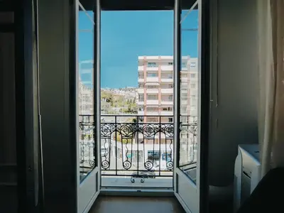 a room with a balcony with a view of a building at Joli Studio - Promenade des Anglais - Accès plage in Nice