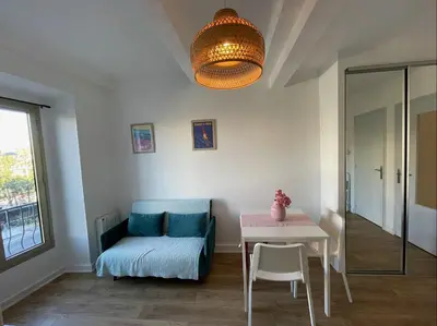 a living room with a table and a chair and a couch at Nice Renting - JAURES - Cosy Flat - Nice old town - Great view - AirCon in Nice