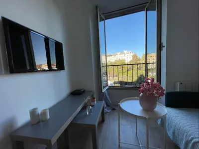 a room with a table with a vase of flowers on it at Nice Renting - JAURES - Cosy Flat - Nice old town - Great view - AirCon in Nice