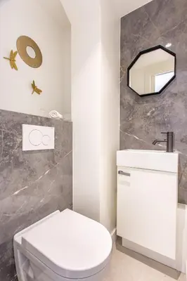 a bathroom with a white toilet and a mirror at I love Nice - FACE MER, DESIGN, TERRASSE, ASC, WIFI, CLIM in Nice