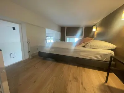 a large bed in a room with a wooden floor at Garibaldi 11 in Nice