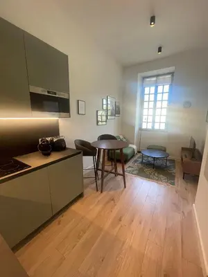 a kitchen and a living room with a table at Garibaldi 11 in Nice