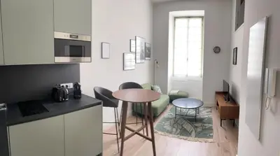 a kitchen with a table and some chairs in a room at Garibaldi 11 in Nice