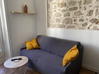 a blue couch with two yellow pillows and a table at Nice Centre: à 300m de la mer et de la Promenade des Anglais in Nice
