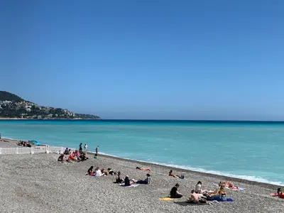 a group of people sitting on a beach at Nice Centre: à 300m de la mer et de la Promenade des Anglais in Nice