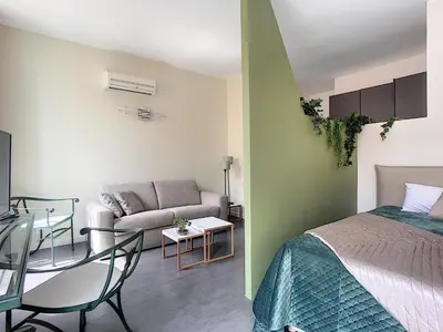 a bedroom with a bed and a living room with a couch at Palais Gioffredo place Massena in Nice