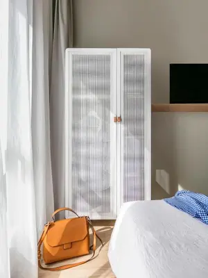 a brown bag sitting next to a bed with a door at OKKO Hotels Nice Aéroport in Nice