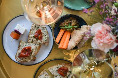 a table with two plates of food and glasses of wine at OKKO Hotels Nice Aéroport in Nice