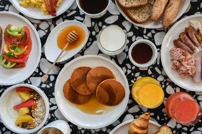 a table full of plates of food on a table at OKKO Hotels Nice Aéroport in Nice