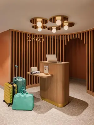a lobby with a desk with a laptop and luggage at OKKO Hotels Nice Aéroport in Nice