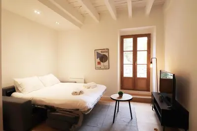 a bedroom with a bed and a tv and a table at Superbe Appartement au coeur de la vieille ville in Villefranche-sur-Mer