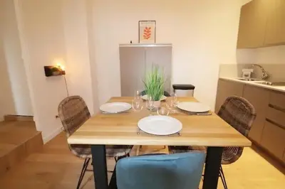 a wooden table with chairs and plates on it in a kitchen at Superbe Appartement au coeur de la vieille ville in Villefranche-sur-Mer