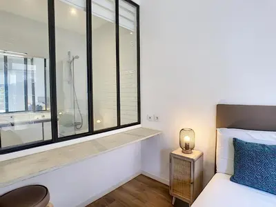 a bedroom with a bed and a window with a shower at Nestor&Jeeves - REINE MARIE TERRASSE - Central - Very close sea - Top floor in Nice