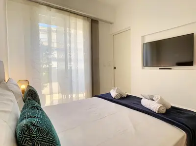 a bedroom with a large bed with a flat screen tv at Nestor&Jeeves - REINE MARIE TERRASSE - Central - Very close sea - Top floor in Nice